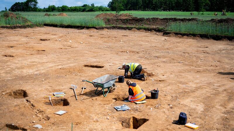 Archäologen finden Siedlungsspuren aus der Bronzezeit Grabungsfacharbeiter erstellen auf einer Baustelle Profilschnitte von Pfostengruben.