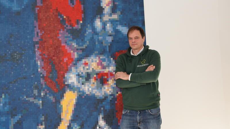 Gracewood-Gründer Matthias Gogolin vor einem Mosaikbild aus Holzplättchen in seinem Unternehmen in Buxtehude. Er plant, das größte Holzmosaikbild der Welt herzustellen.