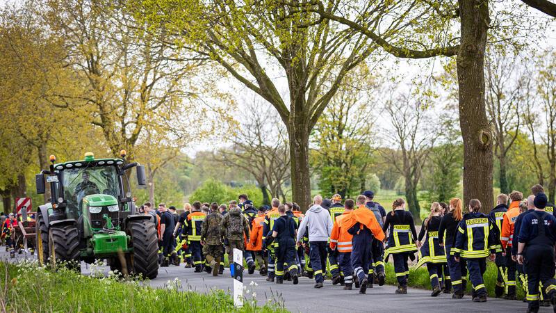 Gräpel: Einsatzkräfte der Feuerwehr gehen eine Straße im Landkreis Stade entlang. Der sechs Jahre alte Arian aus Elm wird weiter vermisst. Die Suche nach ihm geht weiter.