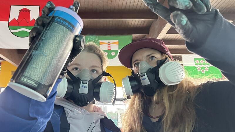 Kinder verschönern das Freibad Hollern-Twielenfleth mit Graffiti Graffiti-Künstlerin Caro (rechts) hilft Pauline beim Sprayen ihrer Graffiti-Schablone.