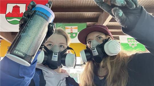 Graffiti-Künstlerin Caro (rechts) hilft Pauline beim Sprayen ihrer Graffiti-Schablone.