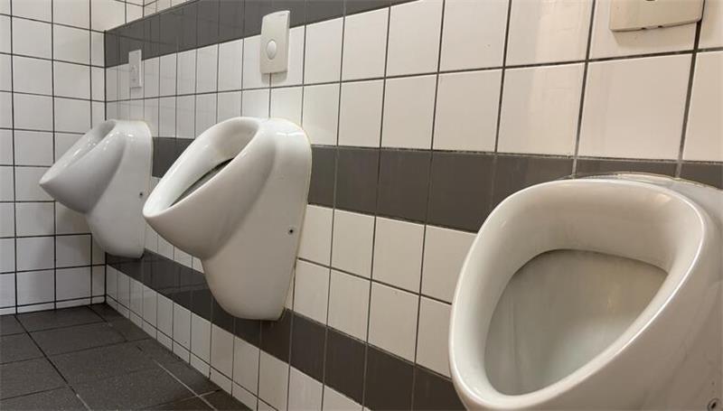 Graue Fliesen setzen Akzente: Urinale in der Männertoilette am Hafen.
