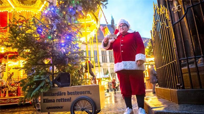 Baum mit Geldsäcken - Aktivisten fordern Milliardärssteuer Greenpeace Bremen hat einen „Wünsche-Tannenbaum“ aufgestellt.