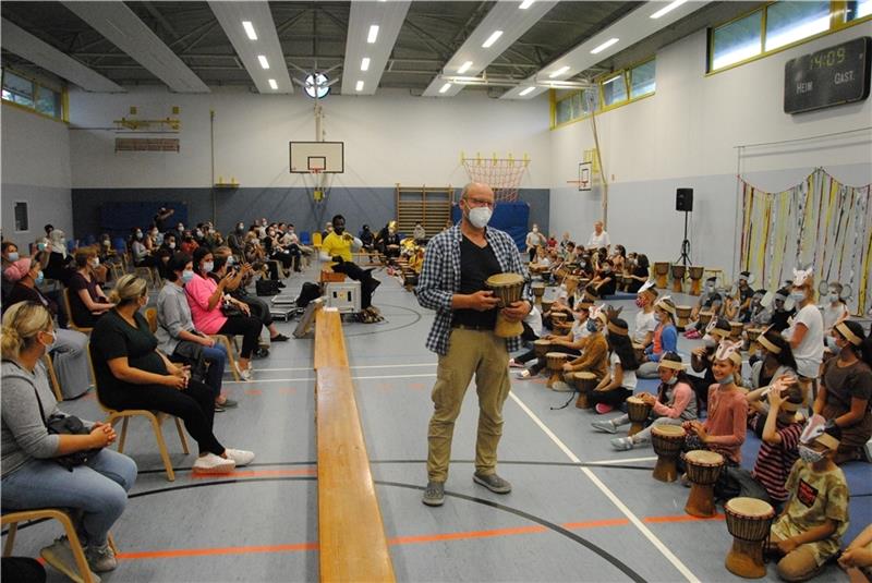 Greift zum Fest auch schon mal zur Trommel: Schulleiter Thomas Heitmann, umringt von Schülern und Eltern. Foto: Stief
