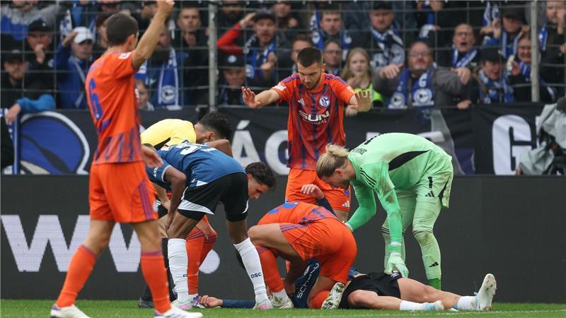 Schalker Abwehrchef hilft bewusstlosem Gegner Grodowski liegt auf dem Rasen.