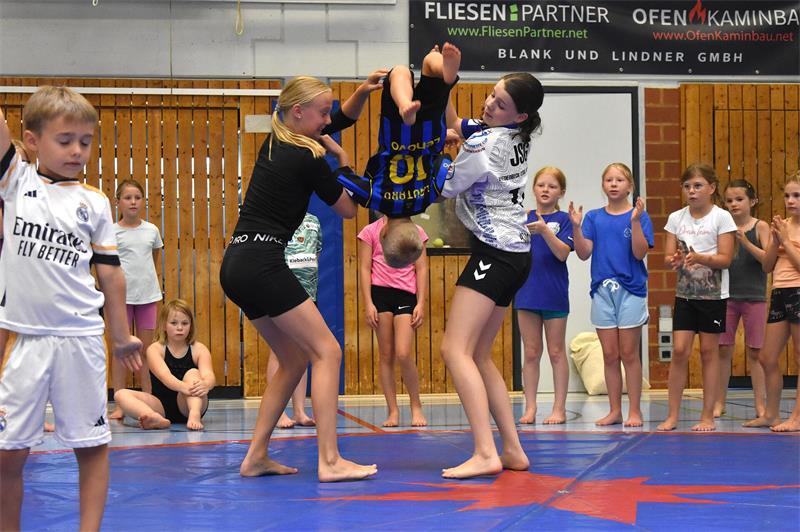 Der Zirkus ist in Fredenbeck: Ein Motto schweißt 67 Kinder zusammen Groß hilft Klein: Die beiden Elfjährigen Marit Klug (links) und Hanni Asmussen halten den Fünfjährigen Felix Dankers (Mitte) fest und geben beim Salto Hilfestellung. Die anderen im Team feuern hinter der Matte an.