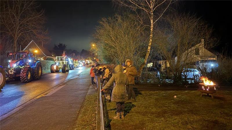 Letzte Lichterfahrt der Funken Crew: Ein Treckerfahrer berichtet Groß und Klein bestaunen am Straßenrand die bunten Trecker.