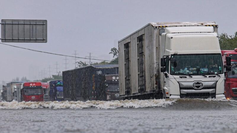 Große Lastwagen fahren durch ein Hochwasser in Shenyang in der nordostchinesischen Provinz Liaoning.