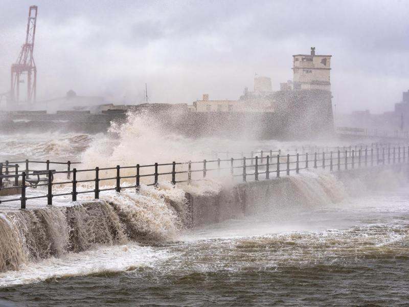 Große Wellen schlagen an eine Hafenpromenade im englischen Liverpool. Foto: Dave Rushen/SOPA Images via ZUMA Press Wire/dpa
