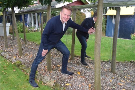Gründer Oliver Rödder zeigt das erste Projekt des Unternehmens: ein Spiegelzaun im heimischen Garten. Foto: Möller