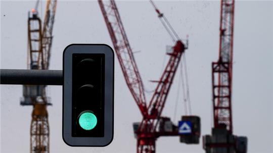 Grüne Ampel vor Kränen am Alexanderplatz in Berlin.