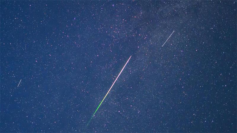Grüner Meteor und Satelliten am Nachthimmel über Brandenburg