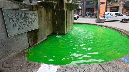 Grünes Brunnenwasser in Hamburg - Klimaaktivisten haben mehrere Brunnen in der Hansestadt mit Uranin eingefärbt, um gegen Kreuzfahrt und LNG-Technologie zu protestieren.
