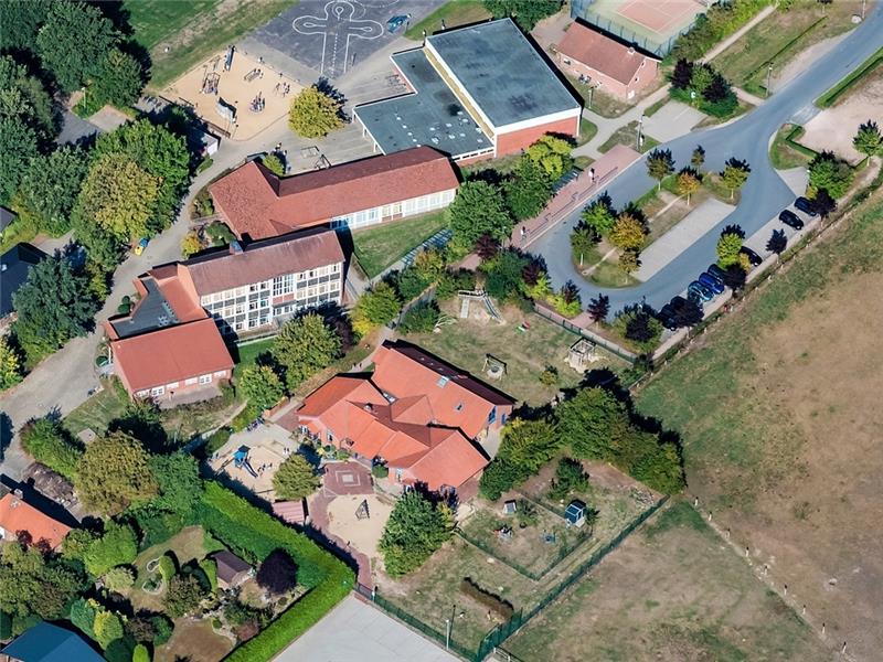 Premiere in der Gemeinde Bargstedt – Alle Bürger eingeladen Grundschule und Kindergarten liegen in Bargstedt direkt nebeneinander. Die Kita soll auf der Fläche mit der gepflasterten Raute und den Sandplätzen erweitert werden. Foto: Martin Elsen