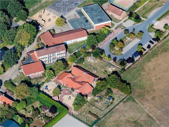 Grundschule und Kindergarten liegen in Bargstedt direkt nebeneinander. Die Kita soll auf der Fläche mit der gepflasterten Raute und den Sandplätzen erweitert werden. Foto: Martin Elsen