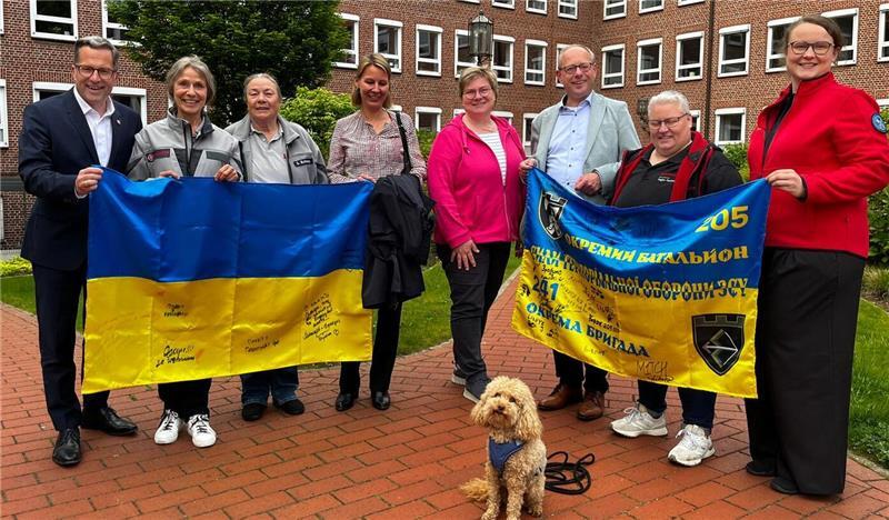 Gruppenbild mit Landrat und Besuchshund Hermine (von links): Kai Seefried, Anke Wehber und Gabriele Behrens von der Besuchshundegruppe der Johanniter, Catharina Dufft (Kirchenkreis Stade), Adelheid Baltasar (Landfrauen), Marc Wischnowsky (Kirchenkreis Stade), Nicole Drewes (Dussmann Service) und Christina Brandt (DLRG).