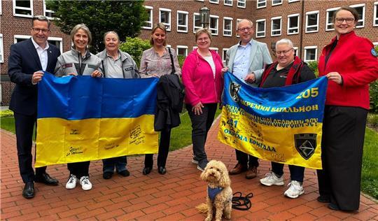 Gruppenbild mit Landrat und Besuchshund Hermine (von links): Kai Seefried, Anke Wehber und Gabriele Behrens von der Besuchshundegruppe der Johanniter, Catharina Dufft (Kirchenkreis Stade), Adelheid Baltasar (Landfrauen), Marc Wischnowsky (Kirchenkreis Stade), Nicole Drewes (Dussmann Service) und Christina Brandt (DLRG).