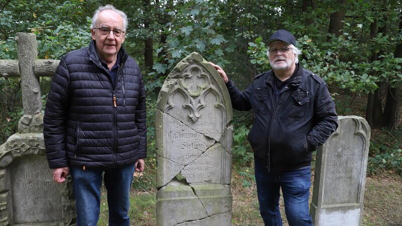 Bedeutende Funde in Brobergen: Warum dieser Friedhof einmalig ist Günther Schimkatis, Vorsitzender des Fähr- und Geschichtsvereins Brobergen (links), und Dietrich Alsdorf (rechts) neben einem der ältesten restaurierten Grabsteine des historischen Bauernfriedhofs.