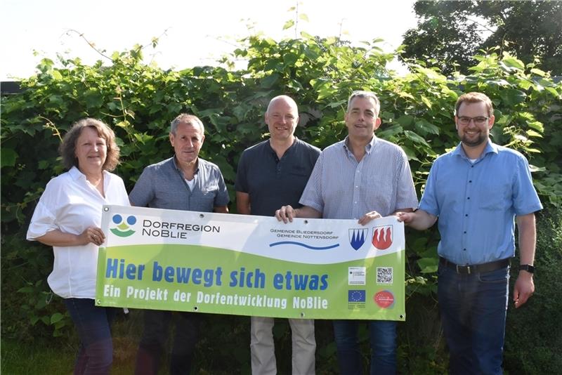 Bliedersdorfer setzen auf Wohnen im Dorf Gunda Kiefaber, Michael Heins, Roger Courtault, Tobias Terne sowie Jan-Henning Pantel halten das Noblie-Banner hoch (von links). Foto: Vasel