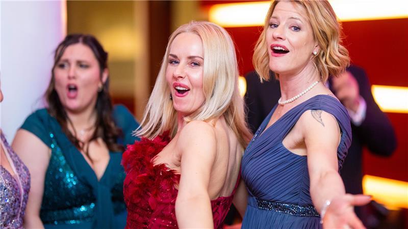 Gut gelauntes Trio in schicken Abendkleidern.