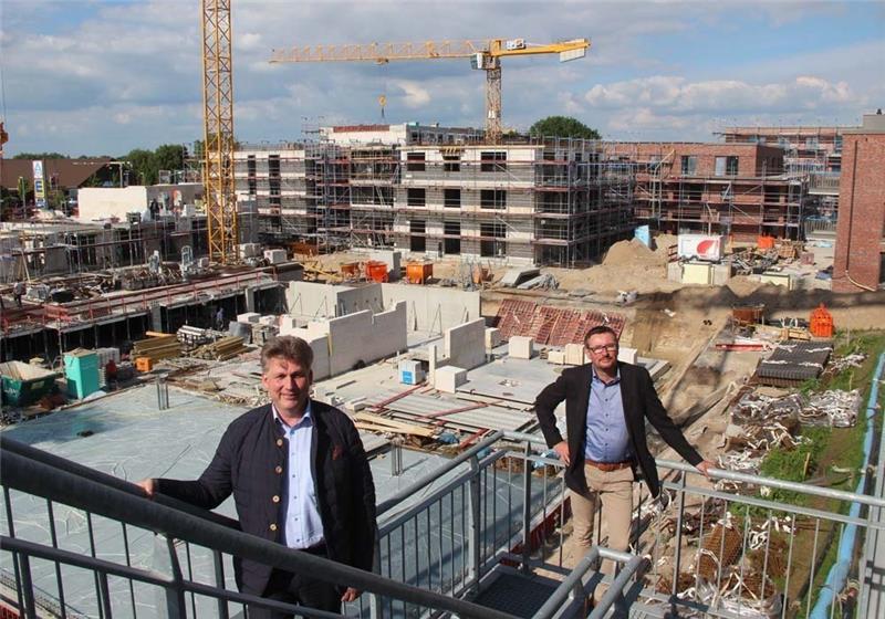 HBI-Geschäftsführer Dierk Heins (links) und Vertriebsleiter Mike Wettering schauen sich die Großbaustelle Wulmstorfer Wiesen vom Parkdeck aus an. Die ersten Häuser sind bereits fertig und rot verklinkert (rechts im Bild). Der erste Bauabschnitt wird Anfang 2021 bezugsfertig. Foto: Michaelis