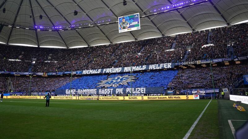 Anti-Polizei-Choreografie bei HSV-Spiel: Polizei durchsucht Hamburger Volksparkstadion HSV-Fans halten Plakate mit der Aufschrift «Niemals Freund, niemals Helfer» und «Ganz Hamburg hasst die Polizei» hoch.