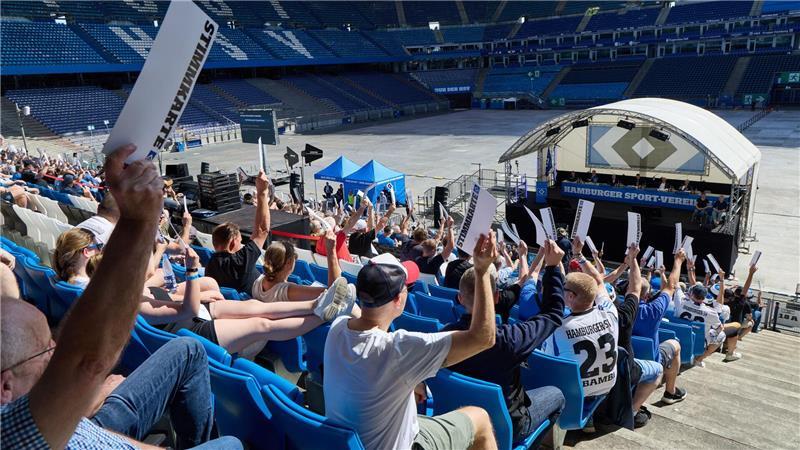 HSV vor Bundesliga-Saison: Schuldenfrei und neuer Präsident HSV-Fans halten Stimmzettel bei der Mitgliederversammlung des Clubs hoch.