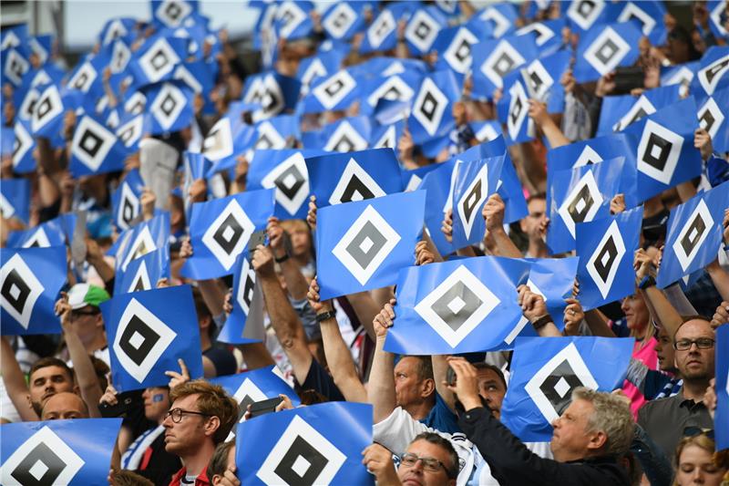 HSV-Fans halten das Vereinslogo hoch. Foto: Daniel Reinhardt/dpa (Archiv).