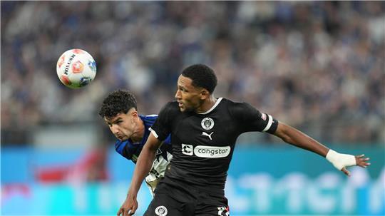 HSV-Profi Daniel Elfadli (l,) und Andreas Hountondji vom FC St. Pauli kämpfen beim Stadtderby um den Ball.