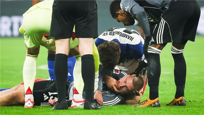 HSV-Verteidiger Luka Vuskovic hilft dem am Boden liegenden Eintracht-Profi Rasmus Kristensen. 