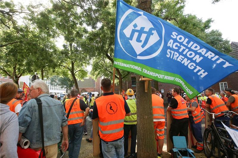 Hafenarbeiter und Teilnehmer stehen während einer Kundgebung zu den Tarifgesprächen in Bremen.
