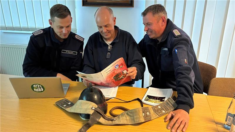 Halten die druckfrische Chronik in Händen: Ortsbrandmeister Jochen Minners (rechts) und sein Stellvertreter Marco Martens nehmen Dr. Dirk Köpcke in ihre Mitte.