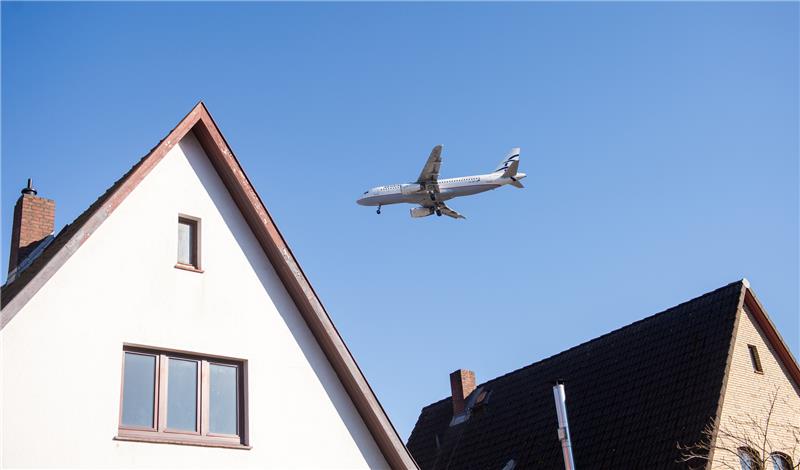 Hamburg: Ein Flugzeug befindet sich über Wohnhäusern im Stadtteil Niendorf im Landeanflug auf den Flughafen. Foto: dpa