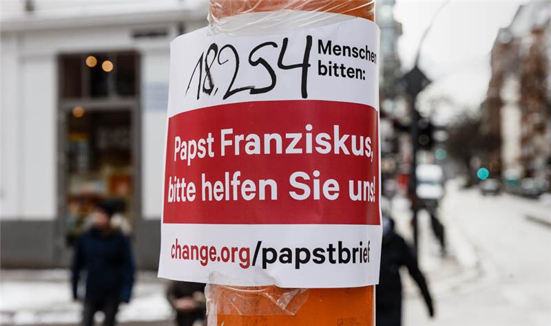 Hamburg: Ein Plakat mit der Aufschrift "Papst Franziskus, bitte helfen Sie uns" hängt im Hamburger Stadtteil St. Georg. Foto: Markus Scholz/dpa +