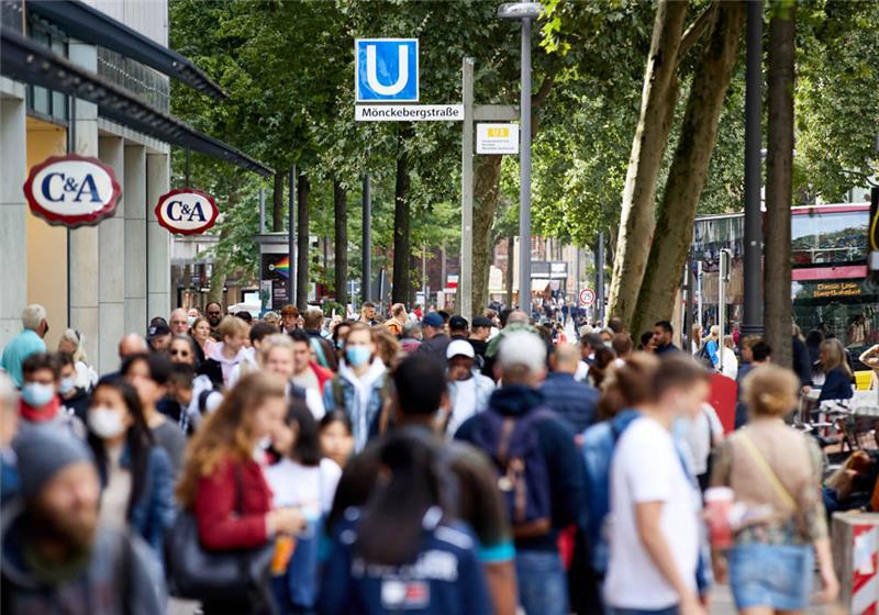 Hamburg: Menschen gehen die Einkaufsstraße Mönckebergstrasse unter dem Schild der U-Bahn-Station Mönckebergstraße entlang. Foto: Georg Wendt/dpa 