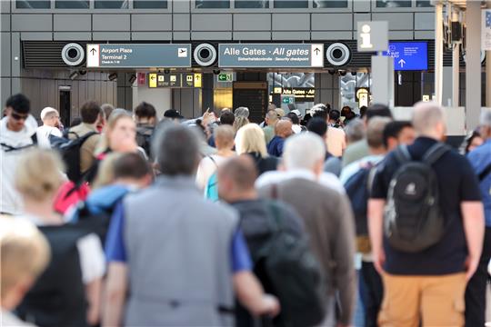 Hamburg: Reisende stehen in einer langen Schlange vor der Sicherheitskontrolle am Hamburger Flughafen an. Foto: Bodo Marks/dpa