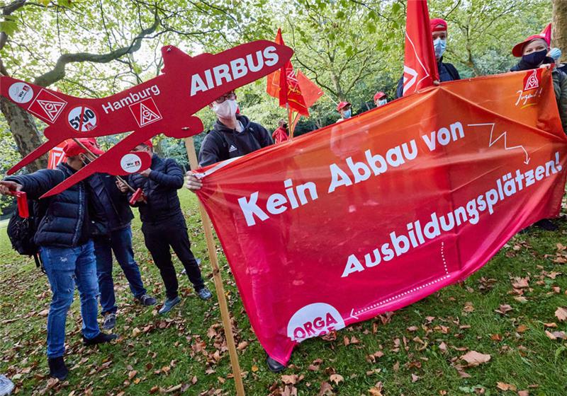 Hamburg: Teilnehmer einer Protestaktion halten Transparente vor Beginn der Tarifverhandlungen zwischen IG Metall und Airbus über Standort- und Beschäftigungssicherung in einem Hotel in der City Nord. Foto: Georg Wendt/dpa 