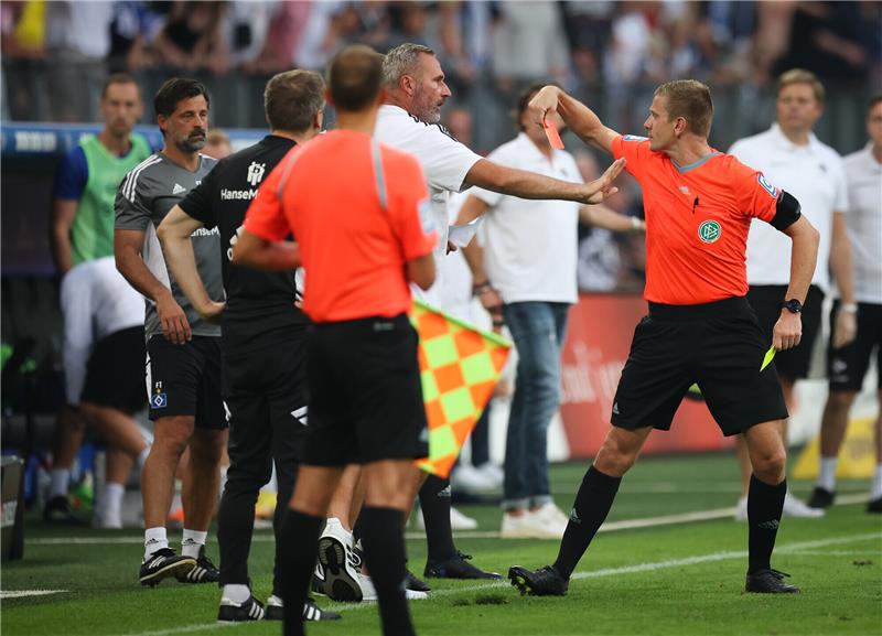 Schiedsrichter wehrt sich nach Aufregung um HSV-Niederlage Hamburgs Jonas Boldt (verdeckt), Sportvorstand Hamburger SV, bekommt von Schiedrichter Robert Schröder (r) die gelb-rote Karte. Foto: Christian Charisius/dpa