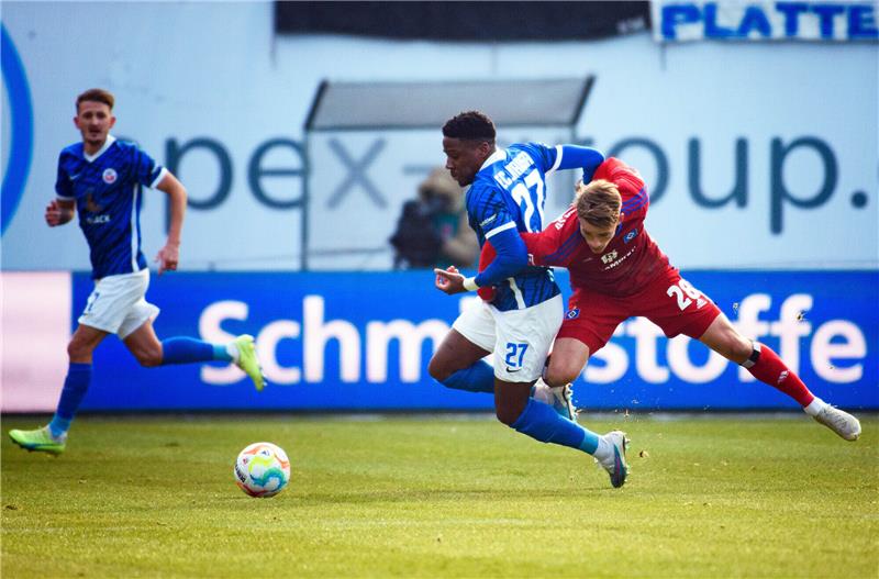 Kein Rückrunden-Einbruch: HSV weiter auf Erstliga-Kurs Hamburgs Miro Muheim (re.) kämpft mit Rostocks Frederic Ananou (Mitte) um den Ball. Foto: Gregor Fischer/dpa