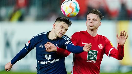 Hamburgs Noah Katterbach (l) und Kaiserslauterns Philipp Hercher kämpfen um den Ball. Foto: Uwe Anspach/dpa