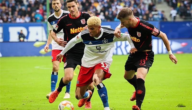 HSV bleibt dran: 3:1 gegen unangenehme Regensburger Hamburgs Ransford-Yeboah Königsdörffer (M) und Regensburgs Jan Elvedi (r) und Maximilian Thalhammer im Kampf um den Ball. Foto: Christian Charisius/dpa