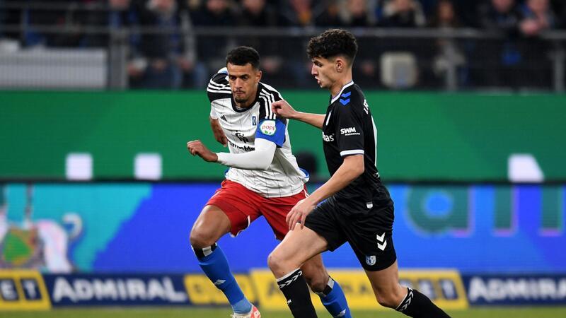 Unterbrechung bei HSV-Spiel: Fans brennen Feuerwerk ab Hamburgs Robert Glatzel (.) und Magdeburgs Daniel Elfadli kämpfen um den Ball.