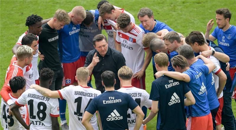 Hamburgs Trainer Christian Titz hat seine Spieler nach dem Abpfiff um sich versammelt. Foto: Axel Heimken/dpa