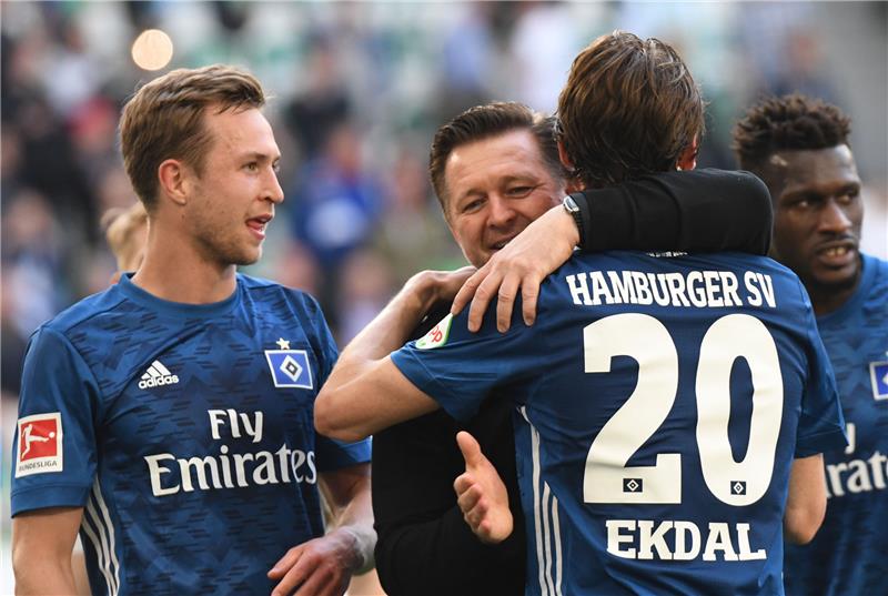 Hamburgs Trainer Christian Titz (zweiter von links) jubelt im Arm von Albin Ekdal nach dem Sieg über den VfL Wolfsburg. Foto Peter Steffen/dpa