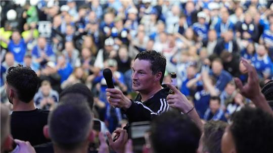 Hamburgs Trainer Merlin Polzin jubelt von der Tribüne den Fans auf dem Rasen zu und feiert den Aufstieg in die 1. Bundesliga.