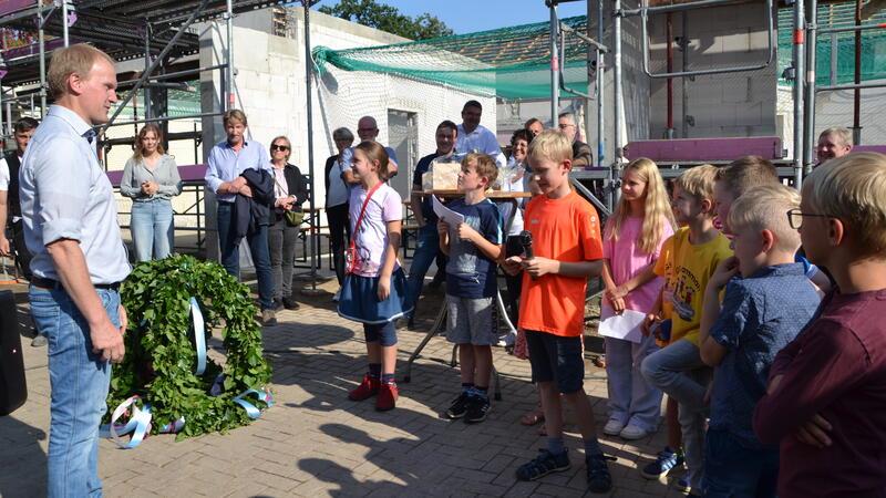 Hammaher Grundschüler handeln mit Bauunternehmer Dirk Holthusen (links) den Preis der Richtkrone aus.