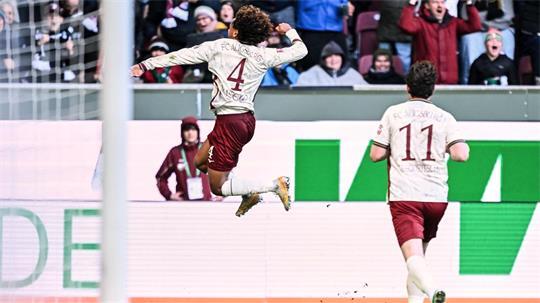 Han-Noah Massengo hebt nach seinem 1:0 jubelnd ab - zum Sieg reichte sein Kopfballtor für den FC Augsburg aber nicht. 