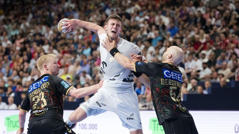 Handball: Champions League, SC Magdeburg - THW Kiel, Finalrunde, Final Four, Spiel um Platz 3, Lanxess Arena. Magdeburgs Spieler Magnus Saugstrup (l) und Oscar Bergendahl (r) versuchen Kiels Mykola Bilyk am Wurf zu hindern.
