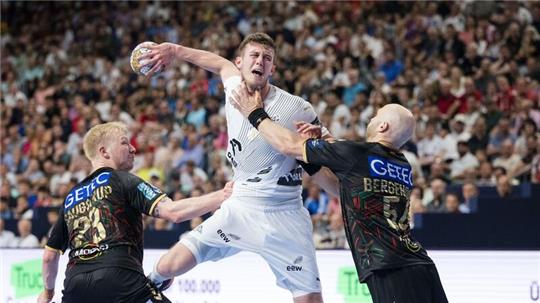 Handball: Champions League, SC Magdeburg - THW Kiel, Finalrunde, Final Four, Spiel um Platz 3, Lanxess Arena. Magdeburgs Spieler Magnus Saugstrup (l) und Oscar Bergendahl (r) versuchen Kiels Mykola Bilyk am Wurf zu hindern.