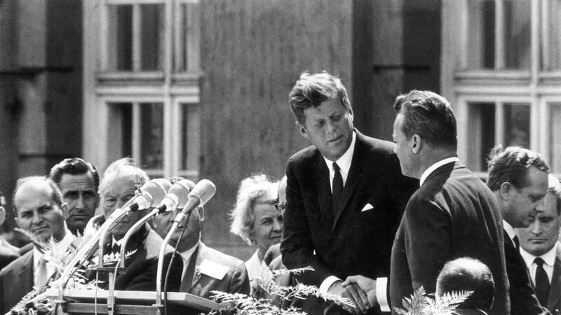 60 Jahre nach Kennedy-Attentat: Biden würdigt Ex-Präsidenten Handschlag in Berlin: US-Präsident John F. Kennedy (M) und der Regierende Bürgermeister von Berlin, Willy Brandt (r), vor dem Schöneberger Rathaus am 26. Juni 1963. Dort sprach Kennedy den legendären Satz „Ich bin ein Berliner“.